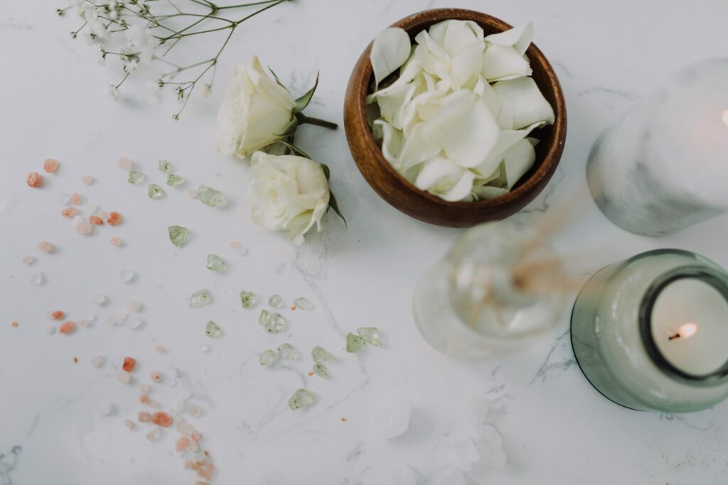 pexels-photo-6724351-6724351 Aesthetic flat lay of white roses, petals, candles, and decorative accents on marble.